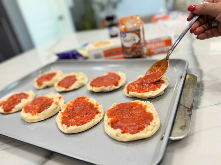 adding sauce to english muffins