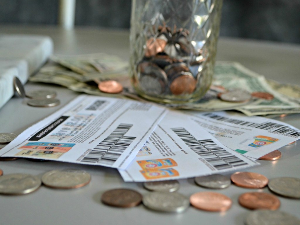 coupons sitting on table with jar of change