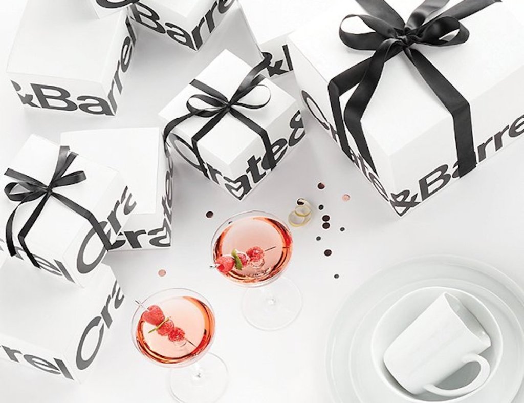 white and black crate and barrel wedding registry gifts with black ribbon and two cocktail drinks