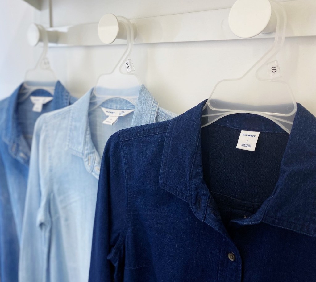 row of dark medium and light chambray shirts on white handers