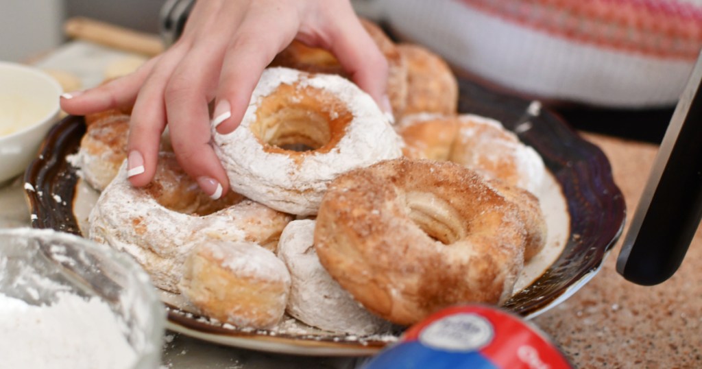 grabbing a donut from a plate