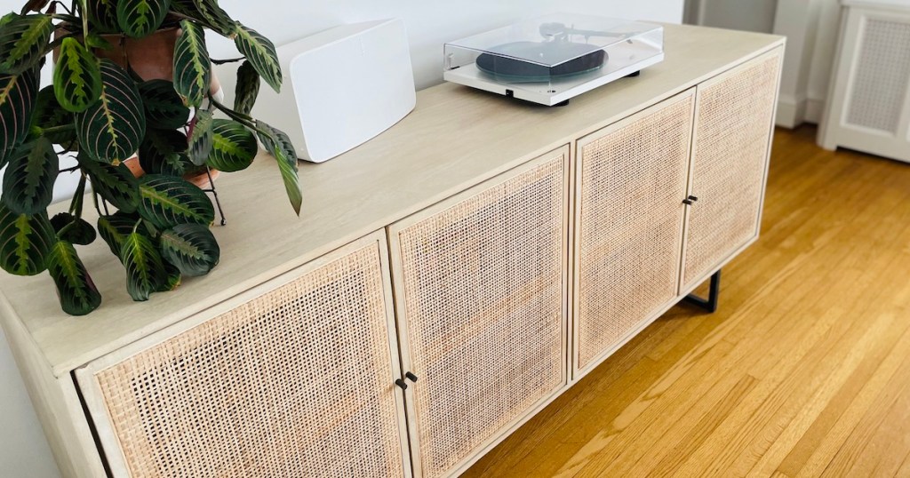 close up of caned console table with plant and turntable