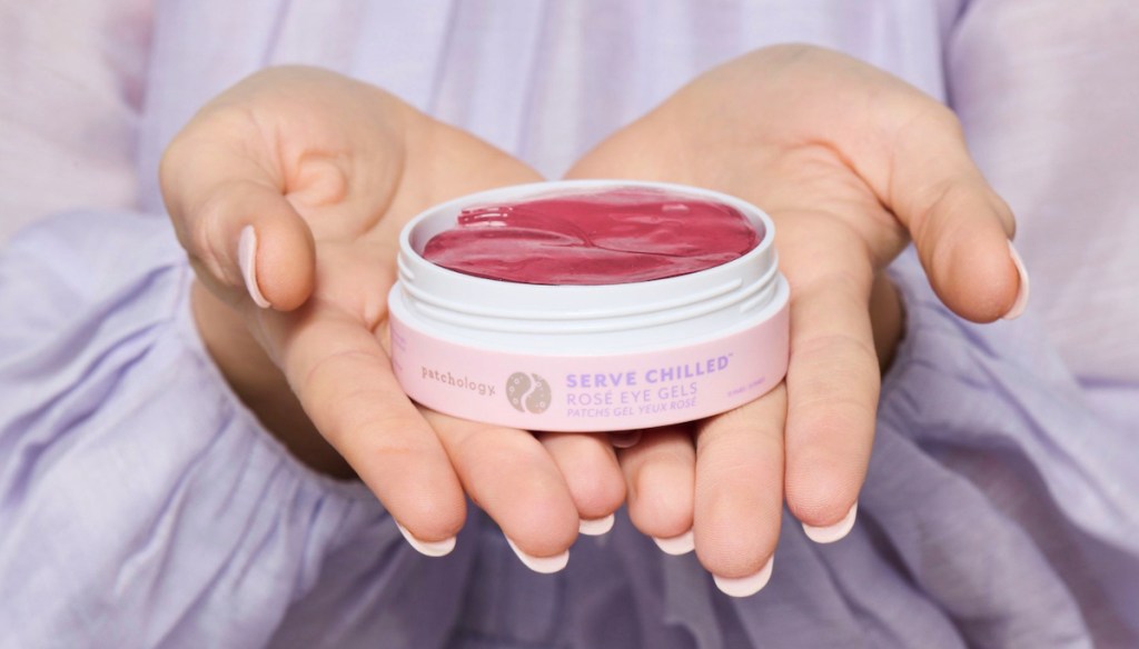 hands holding out container of rose eye gels 