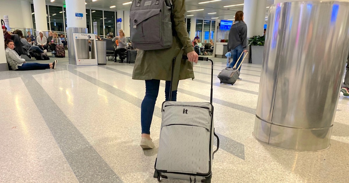 woman traveling through airport with carry on luggage as a helpful packing tip