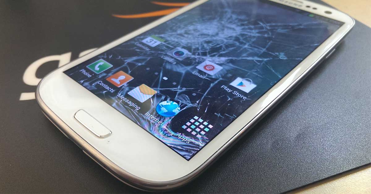 samsung galaxy phone laying on a table with a cracked screen