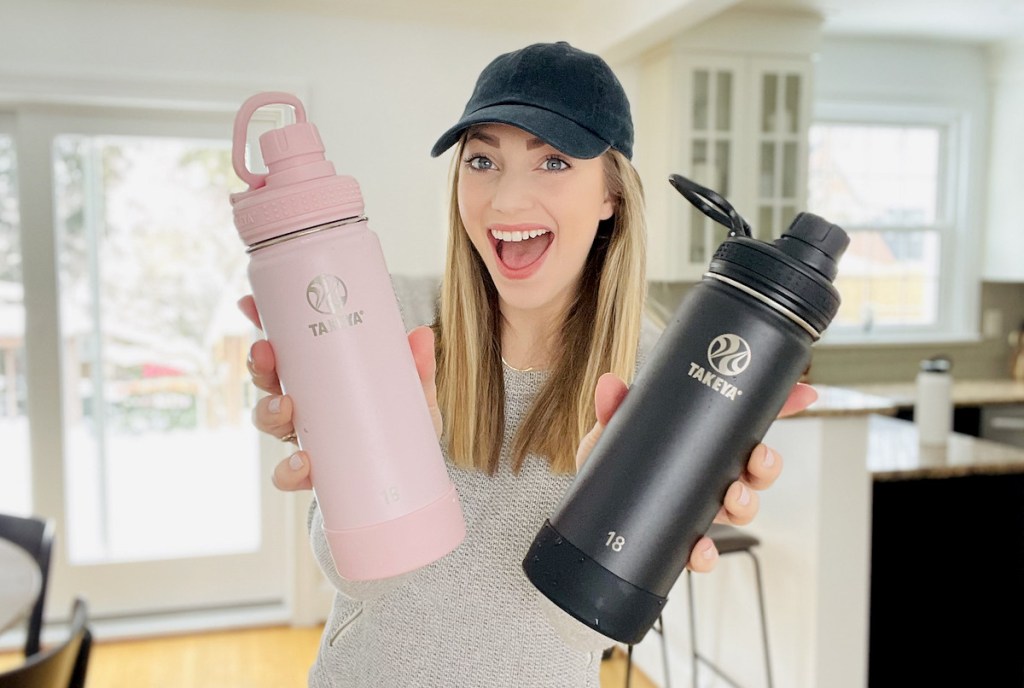 woman holding pink and black takeya water bottles