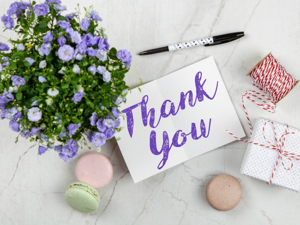 thank you card with flowers and treats on table