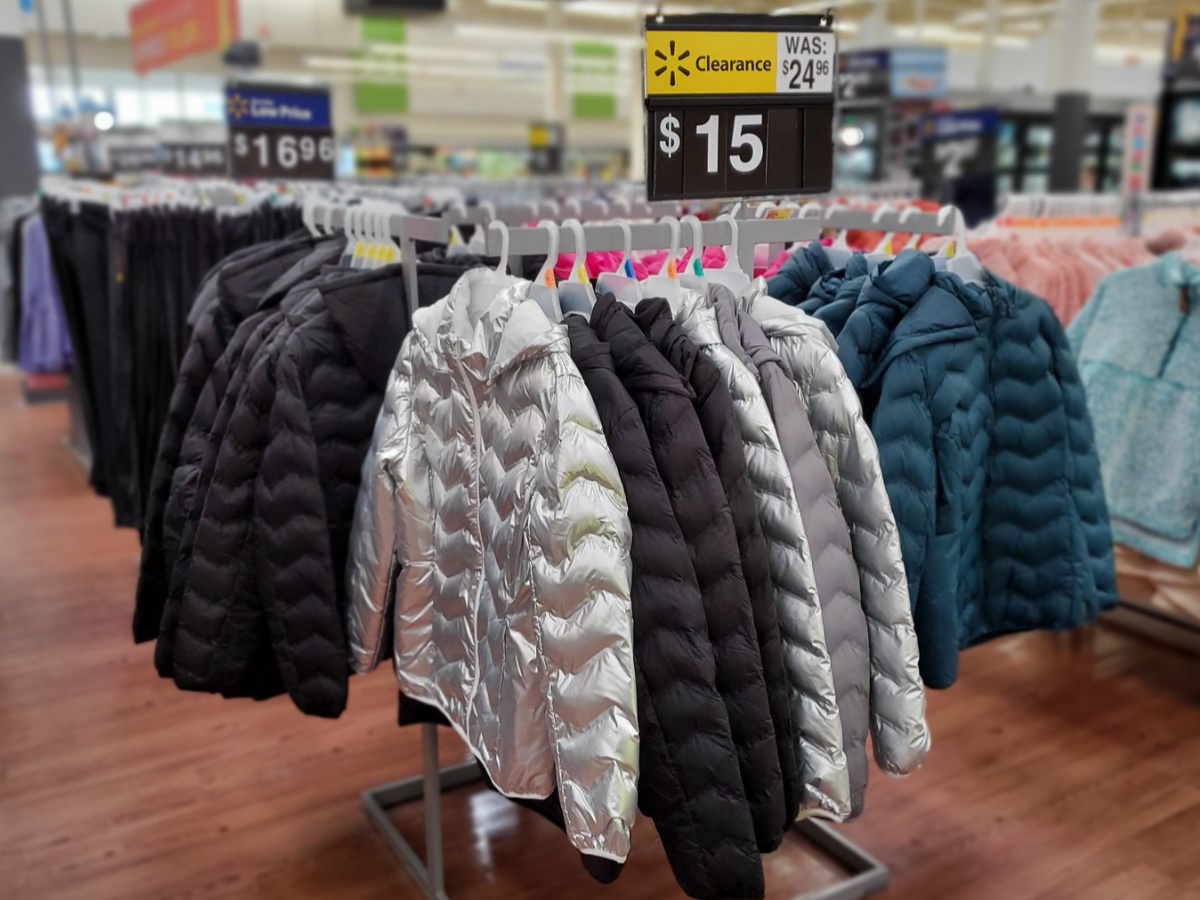 silver, black and blue puffer jackets hanging on rack in store 