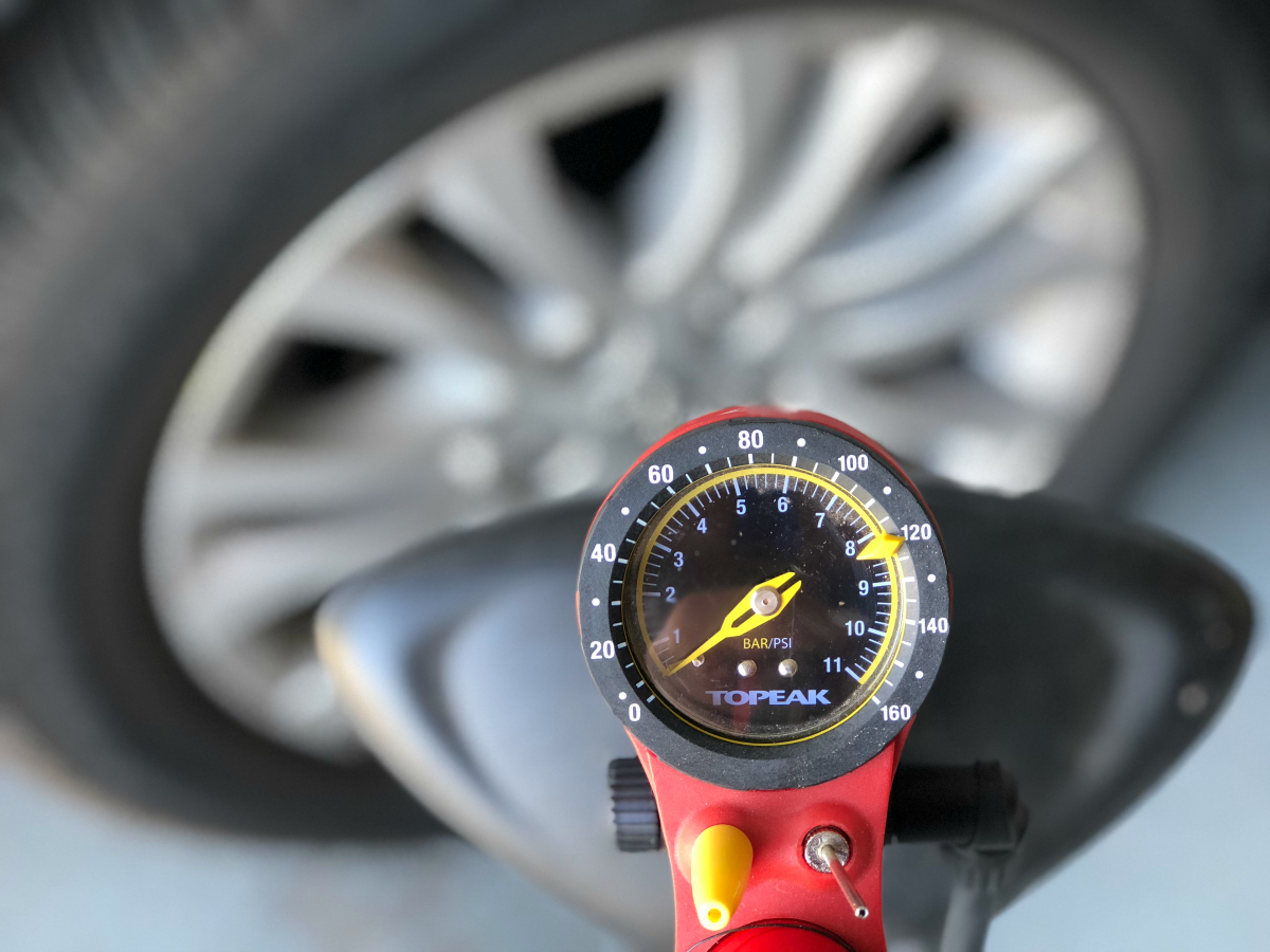 tire pressure gauge in front of car tire