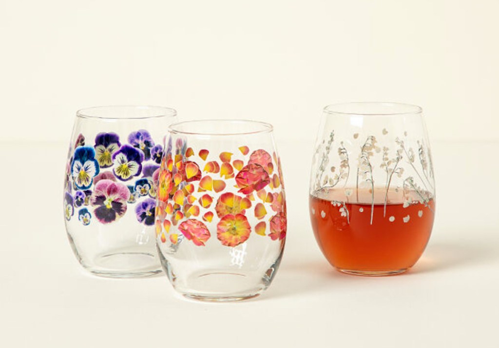 three colorful pressed flower drinking glasses sitting on stock background