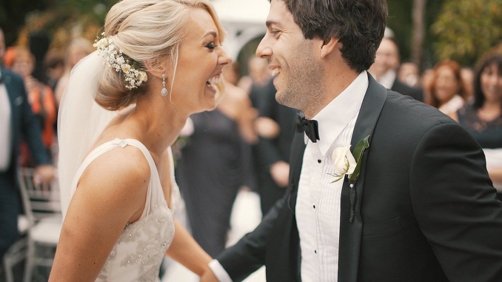 bride and groom laughing and looking at each other