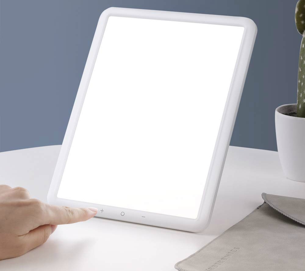 woman pushing button on TaoTronics Light Therapy Lamp