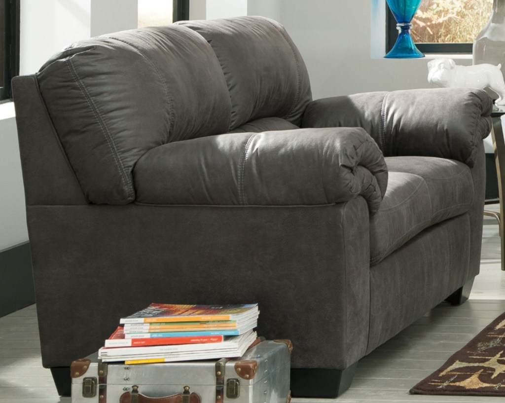 Large dark gray sofa in living room near storage trunk