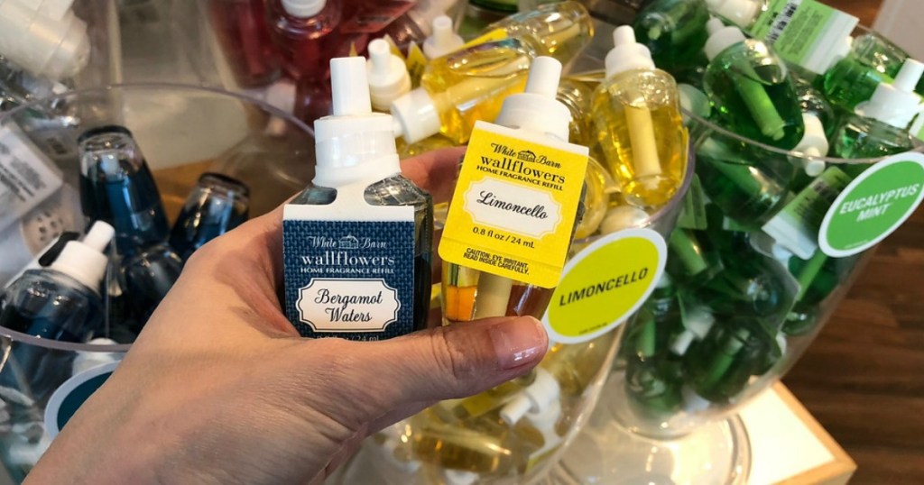 blue and yellow wallflower fragrance refills being held by a woman