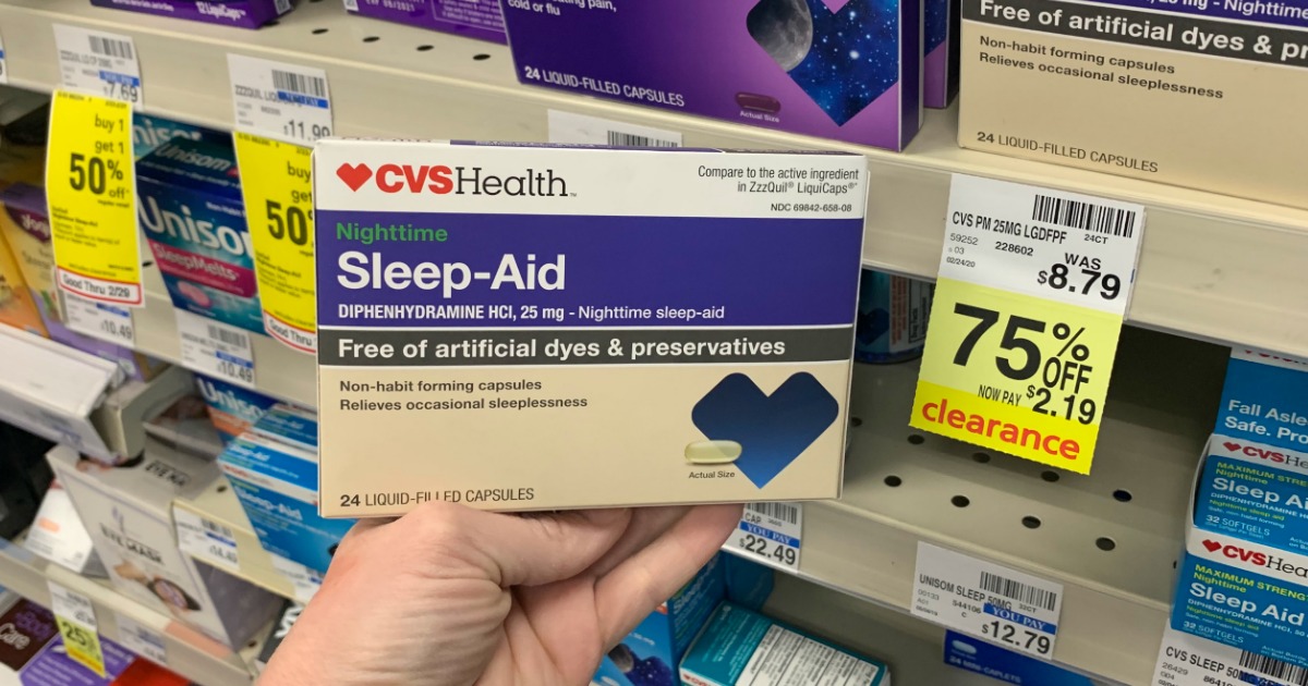 Hand holding sleep medicine in front of shelf