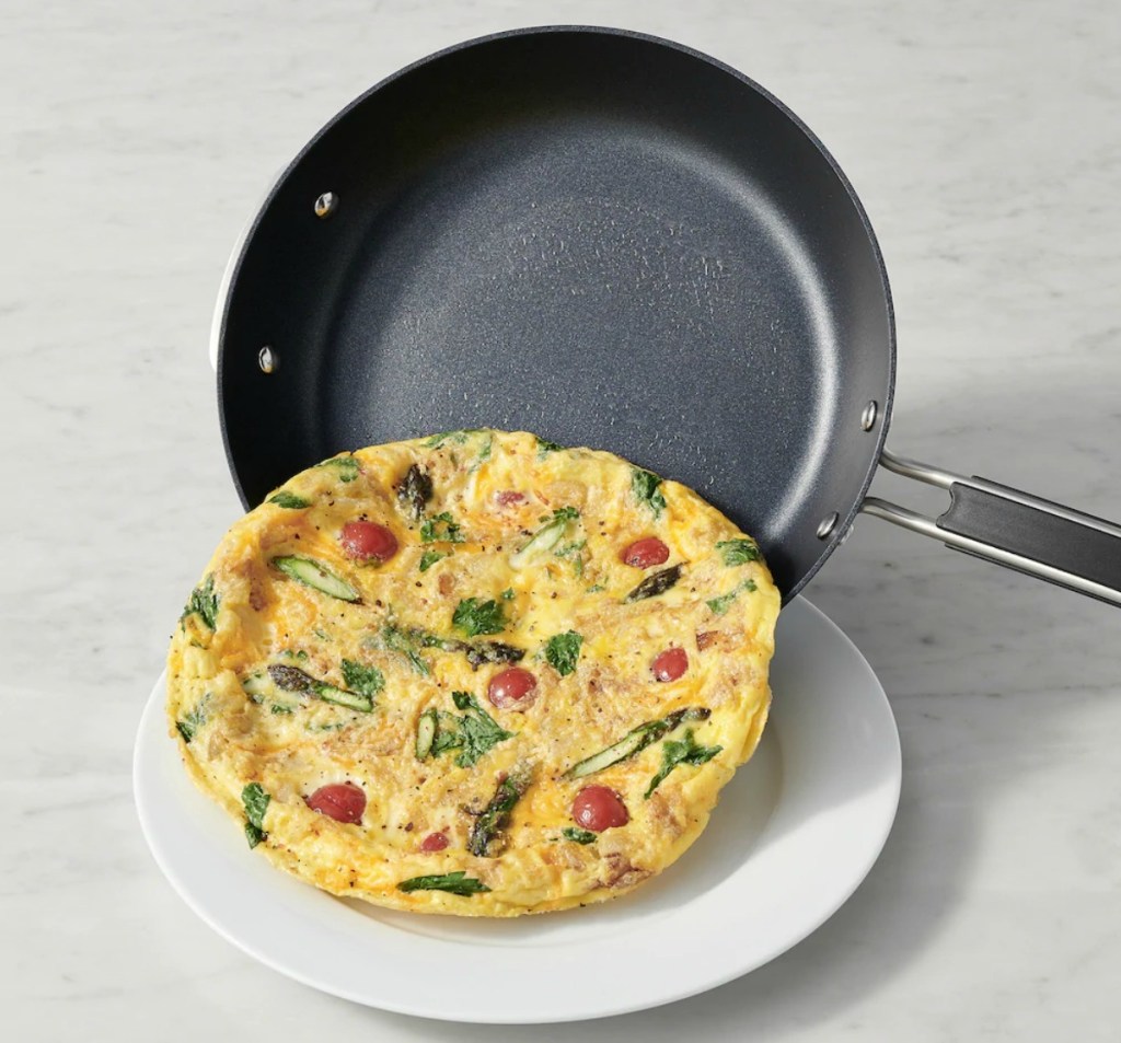 Small quiche sliding out of a nonstick pan onto a small white plate