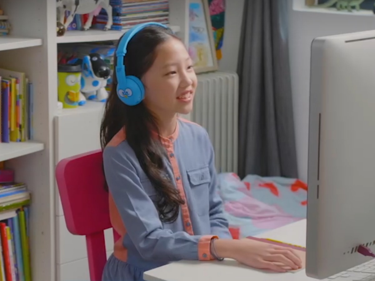 girl wearing headphones and working on desktop computer