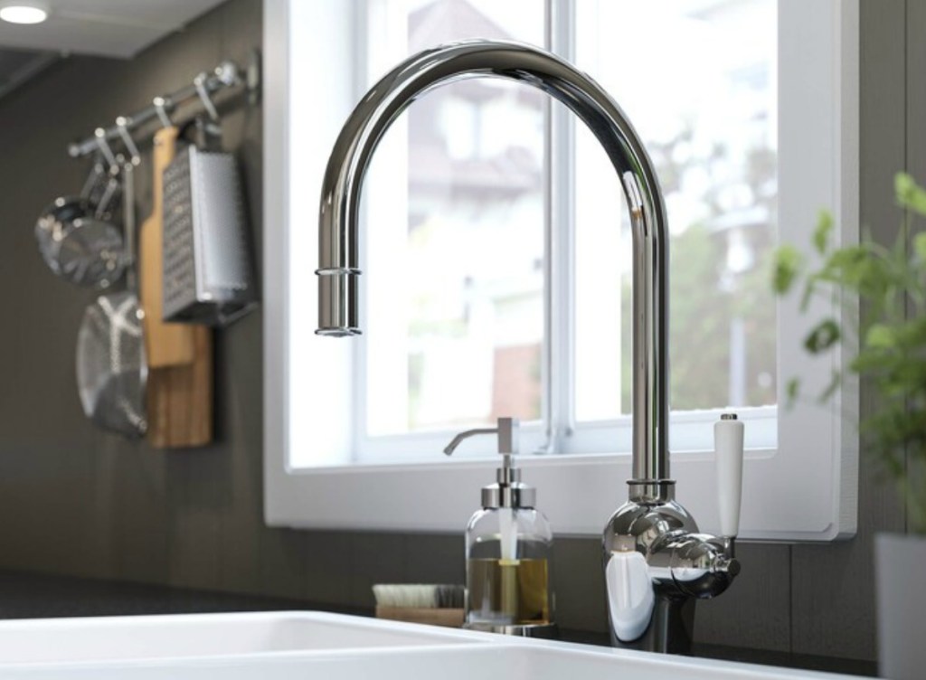 Large stainless steel kitchen faucet installed in kitchen sink