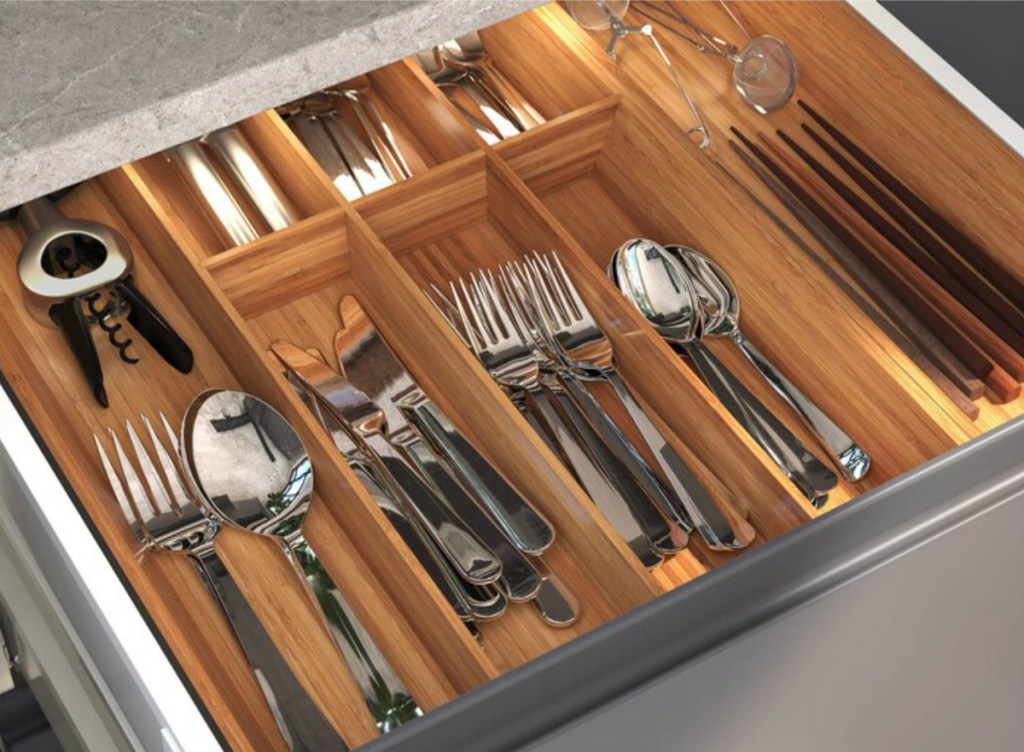Large wooden flatware organizer filled with a matching set of forks, spoons, and knives