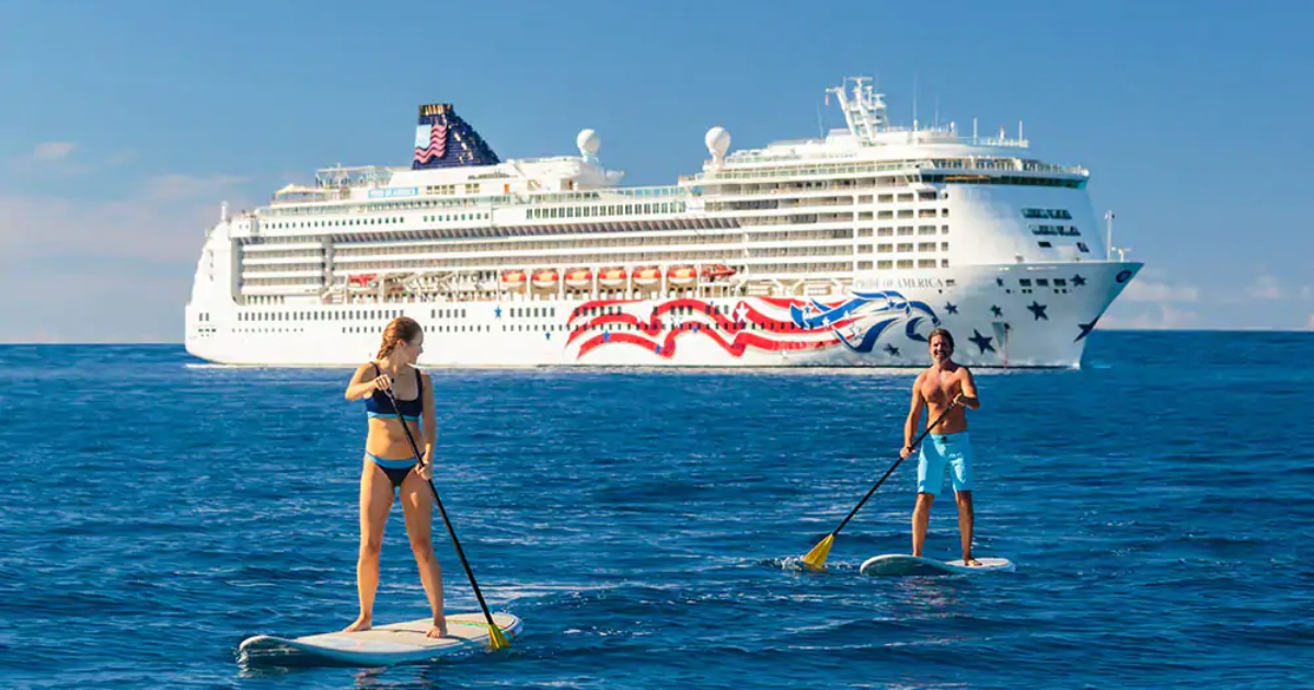 Norwegian cruise ship with paddleboarders in foreground