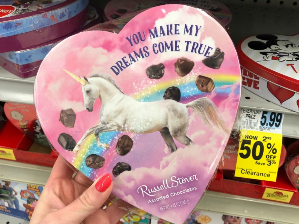 Hand holding a large unicorn themed heart shaped box of chocolates