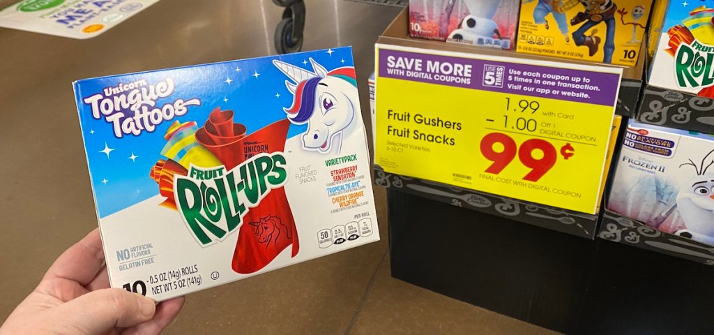 hand holding box of Unicorn Tongue Tattoo Fruit Rollups by sign at Kroger