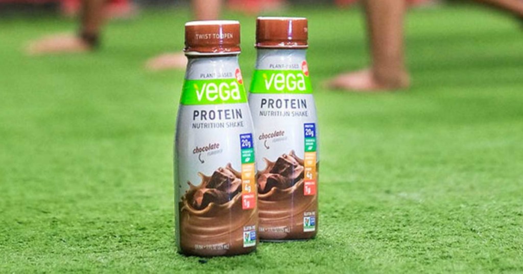 Vega Protein Shakes on grassy field with people in the background