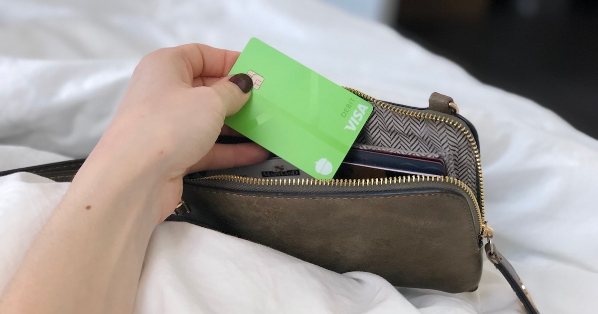 hand holding a bright green visa card with wallet