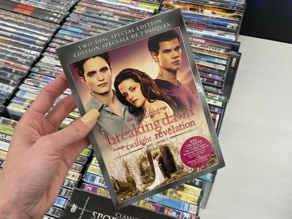 hand holding DVD movie by store display