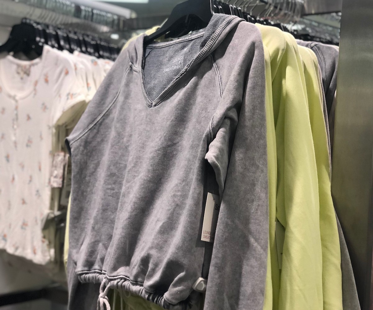 gray sweatshirt hanging on clothes rack 