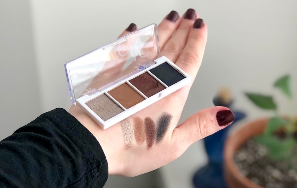 hand holding elf eyeshadow palette with eyeshadow on top of hand