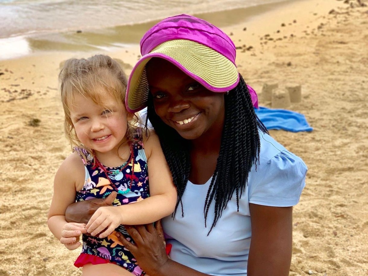 nanny with girl on beach