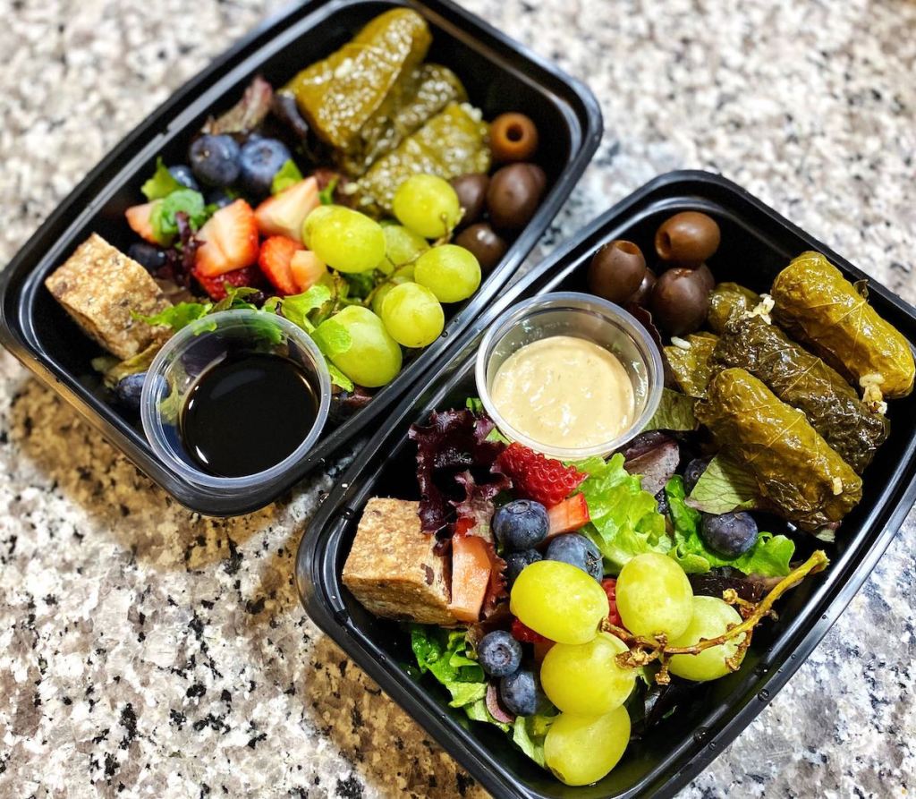 two containers filled with food and condiments 