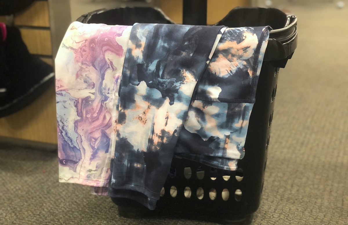 two pairs of tie dye leggings hanging on black shopping basket