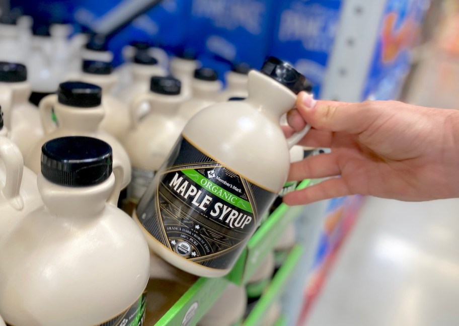 hand pulling out maple syrup carton from bulk store shelf