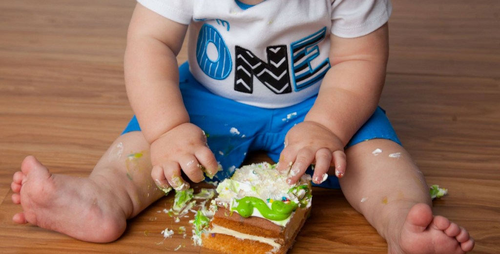 boy with one shirt sitting on wood floor with mess