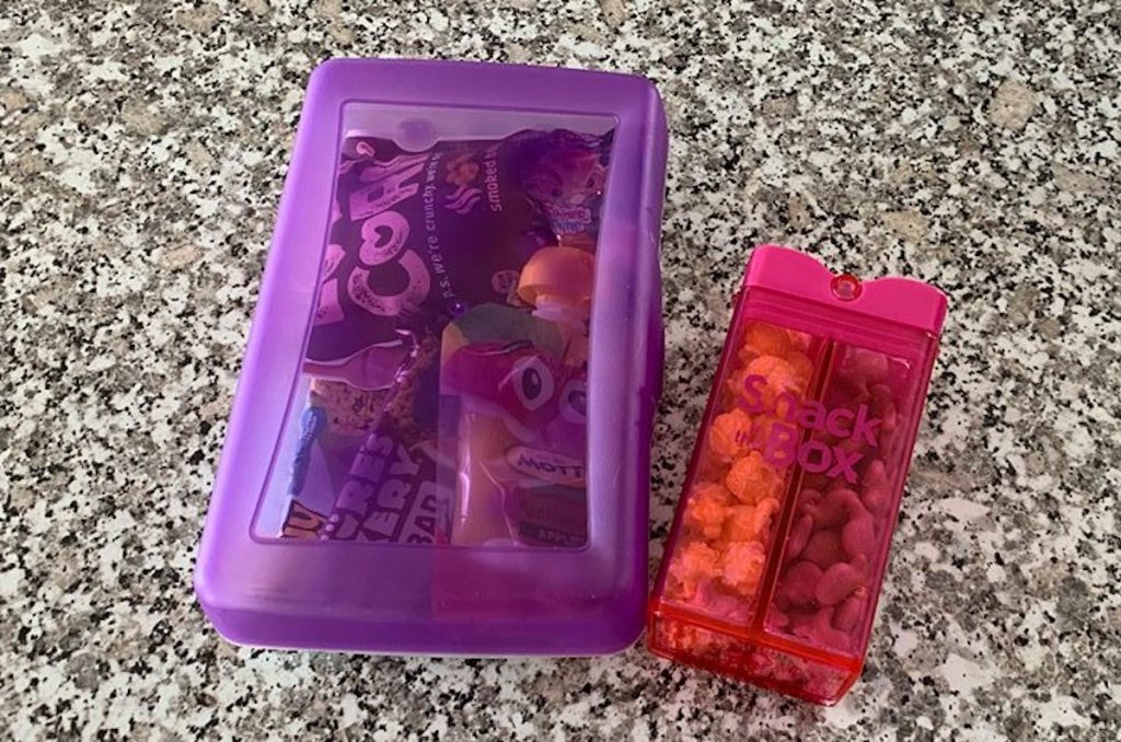 purple and pink snack boxes sitting on granite countertop