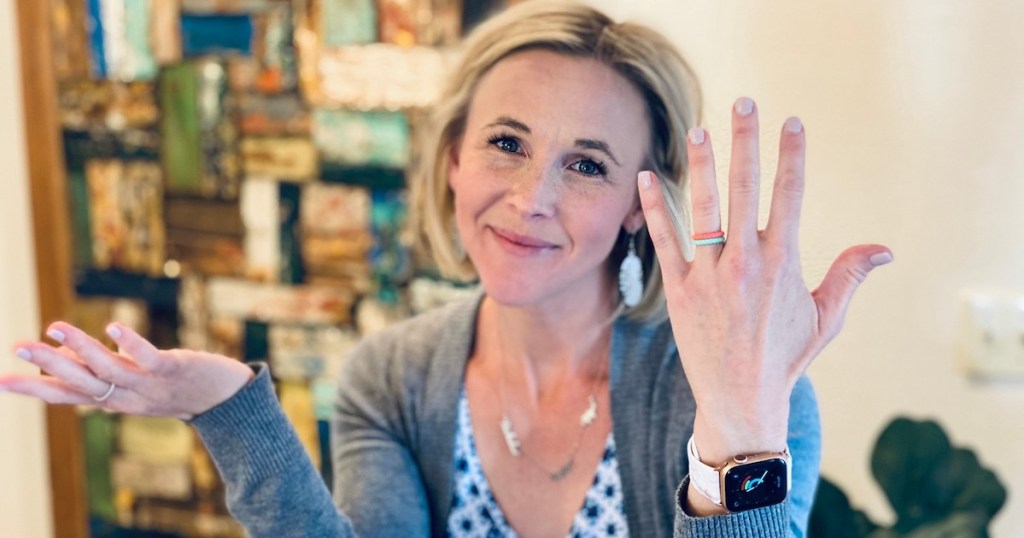 woman holding up hand with alternative engagement rings silicone rings on ring fingers