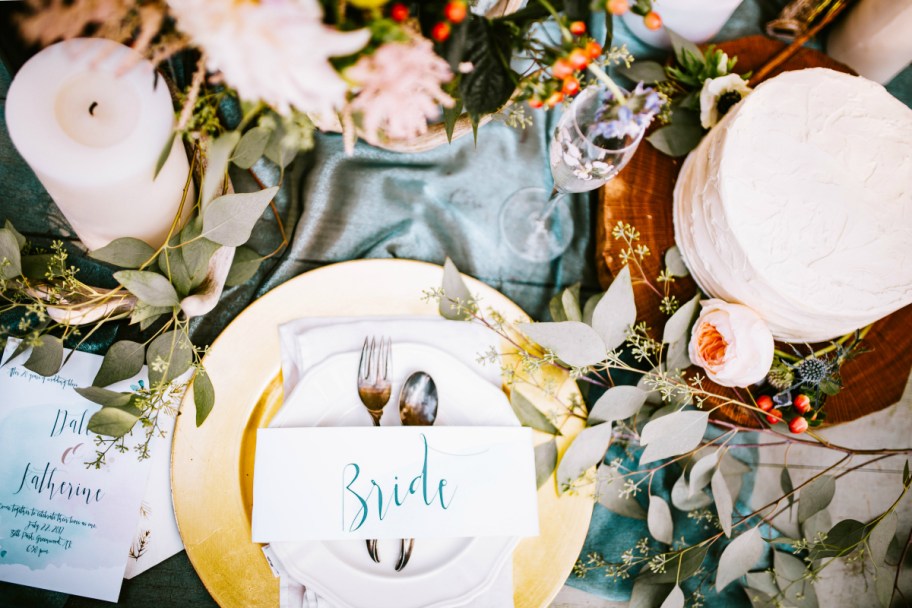 wedding table setting with flowers candles and cake