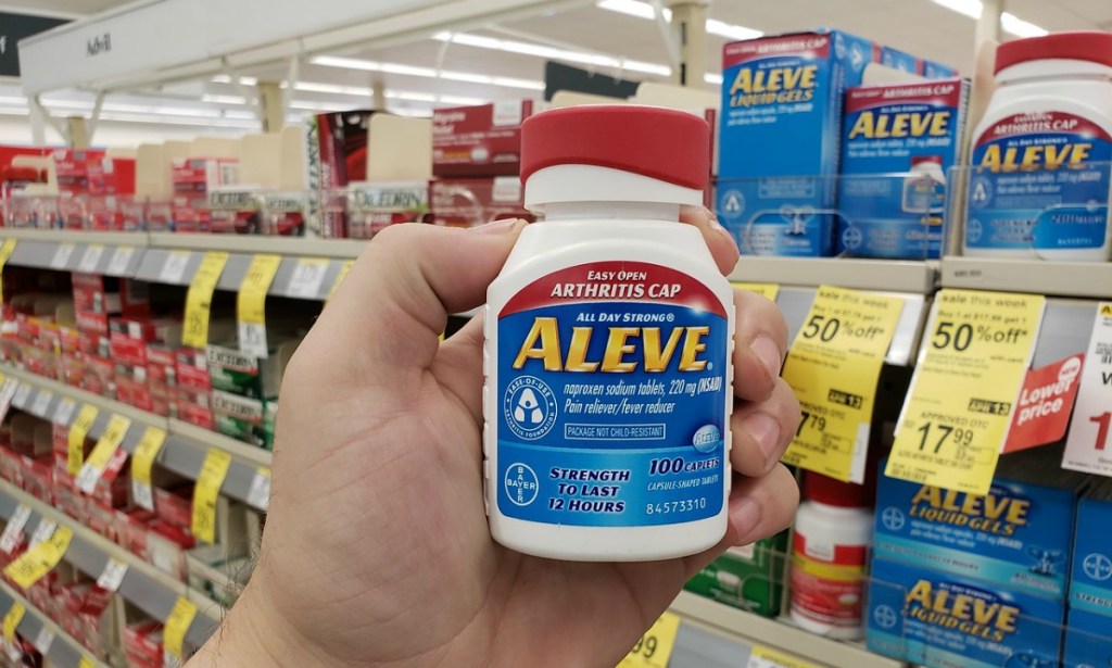 man holding up a bottle of Aleve