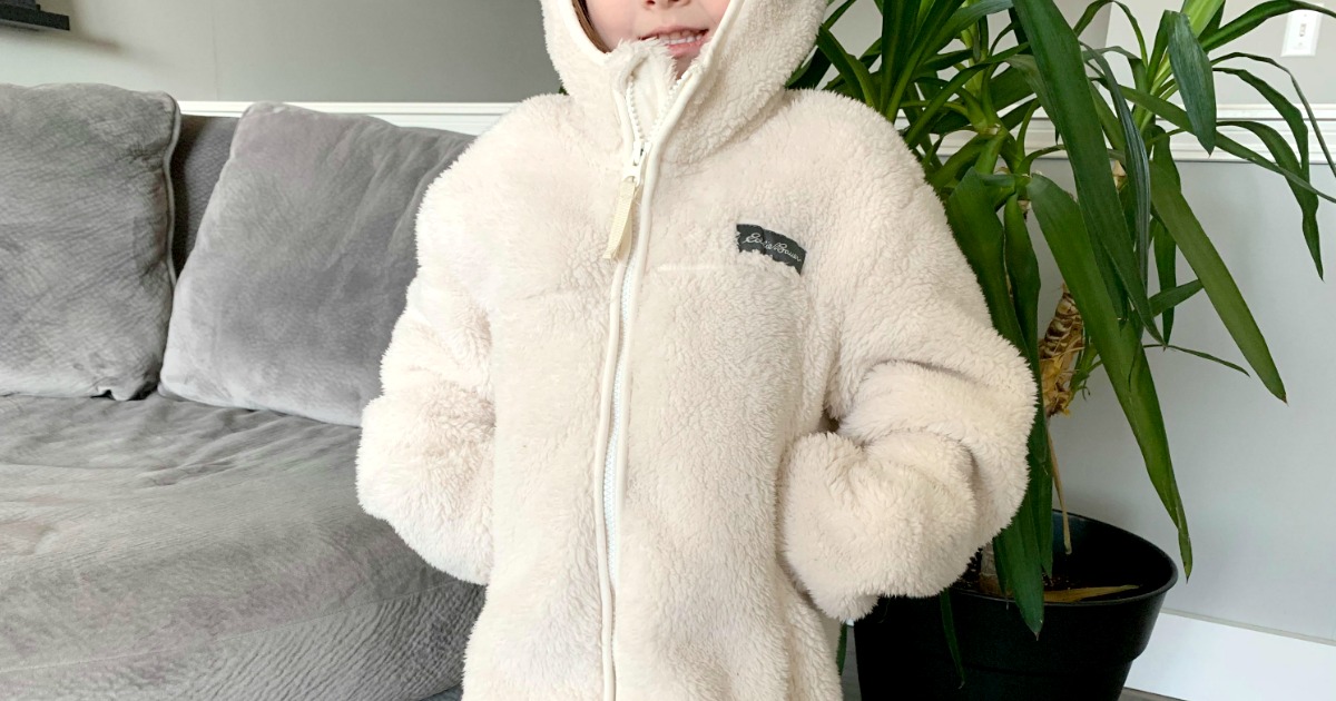 Young girl wearing a large plush white jacket