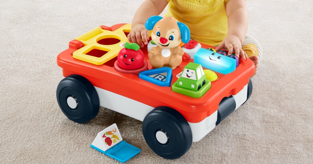 young child playing with toy wagon