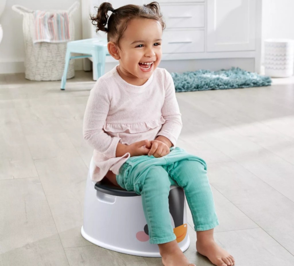 little girl sitting on a Fisher-Price potty