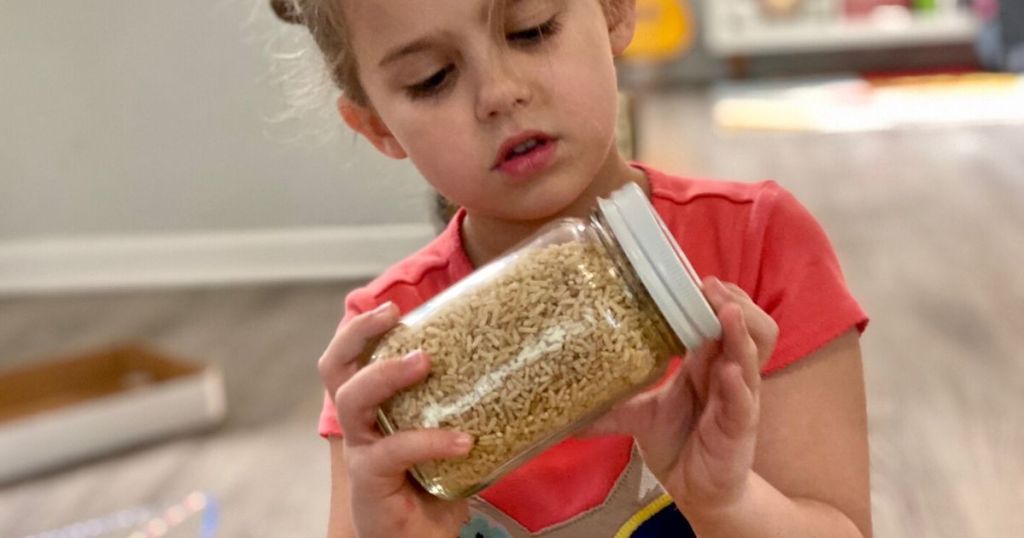 Little girl looking for items in DIY I-Spy jar