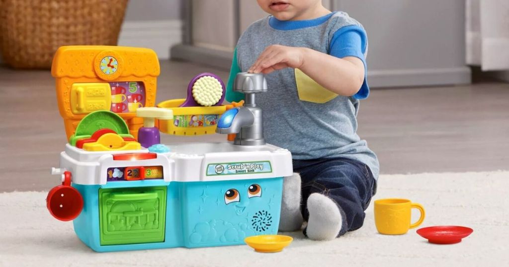 little boy playing with toy sink set on carpet