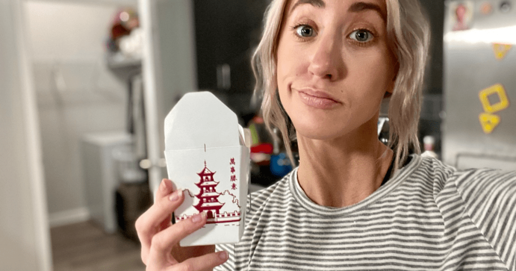 Woman holding leftover white rice in kitchen