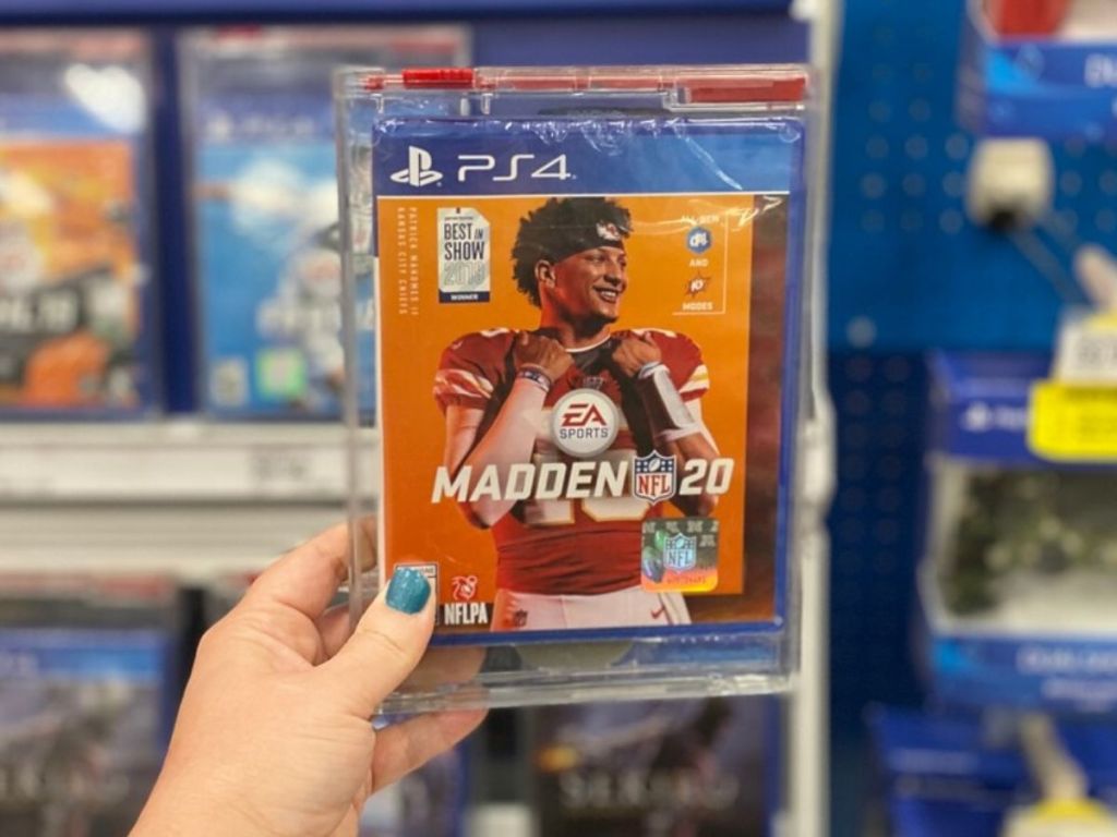 womans hand holding up football video game in case at store