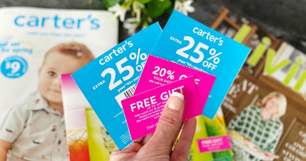 lady holding various coupons for Carter's, BBW and more