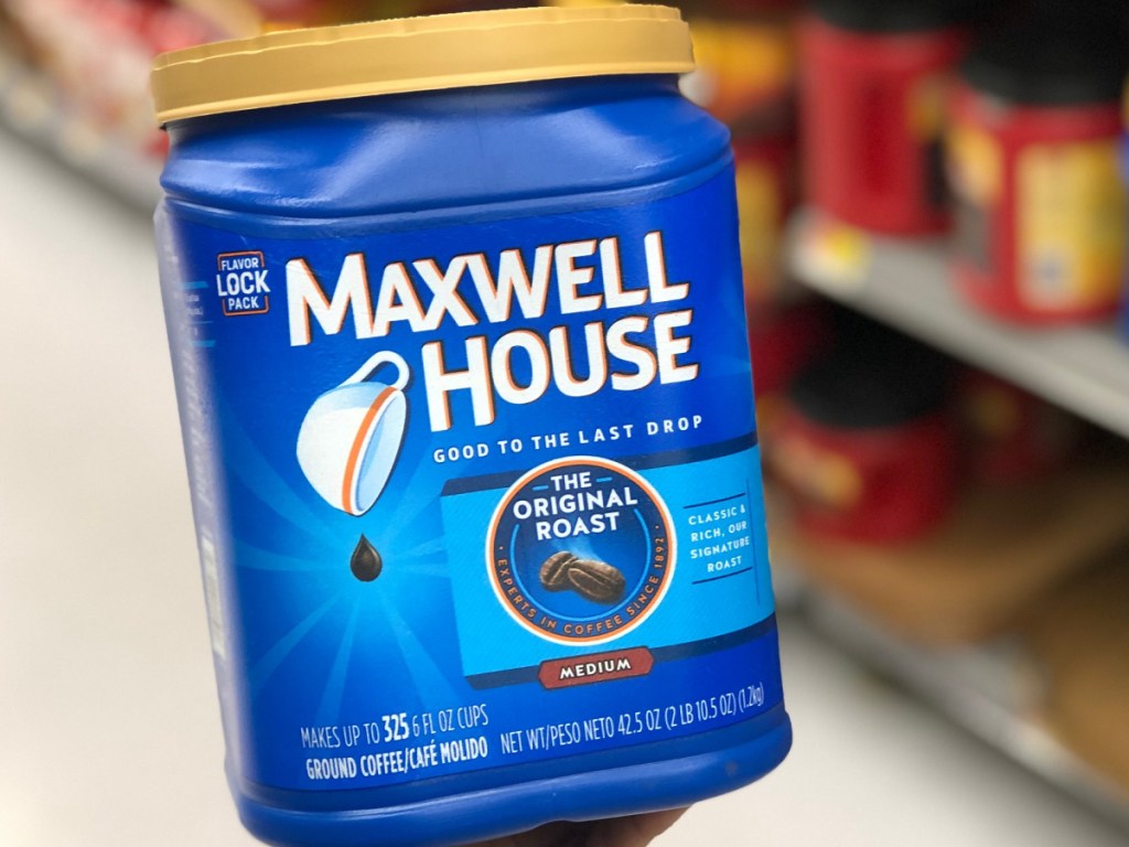 Hand holding large canister of Maxwell House coffee