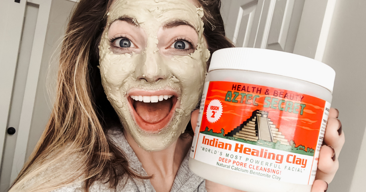 Woman wearing Indian Healing Clay mask and holding jar in hand